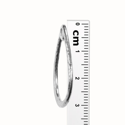 TierraCast Stitch-around Teardrop Charm / plated pewter with a white bronze finish / side view with ruler